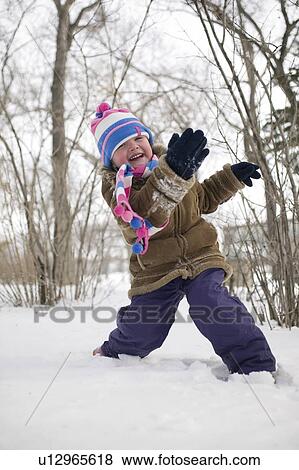Stock Photo - Young child throwing snow, Regina, Saskatchewan, Canada. Fotosearch
