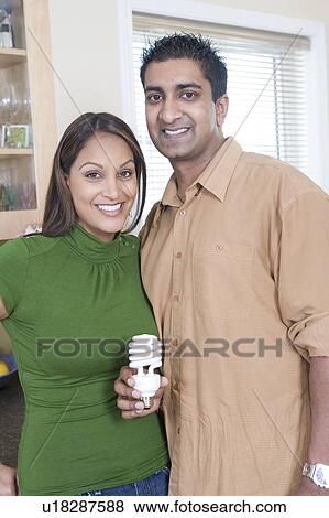 Couple holding energy efficient compact flourescent bulb, Winnipeg, Canada View Large Photo Image Stock Photo - Couple holding energy efficient compact flourescent bulb, Winnipeg, Canada. Fotosearch