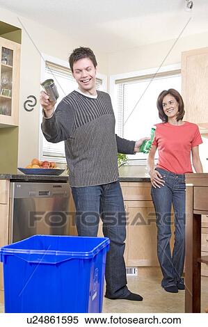 Couple laughing in kitchen as man tosses can into recycling bin, Winnipeg, Canada View Large Photo Image Stock Photography - Couple laughing in kitchen as man tosses can into recycling bin, Winnipeg, Canada. Fotosearch