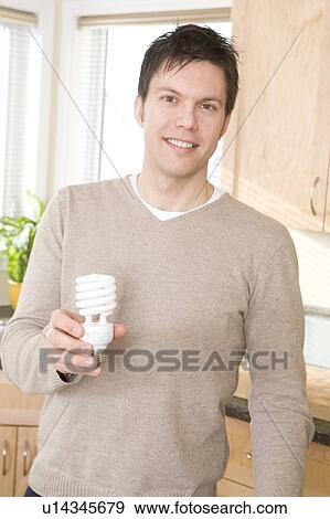 Man holding energy efficient compact flourescent bulb, Winnipeg, Canada View Large Photo Image Stock Photo - Man holding energy efficient compact flourescent bulb, Winnipeg, Canada. Fotosearch