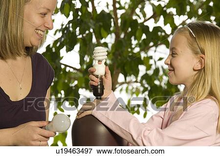 Mother and daughter replacing an energy efficient light bulb View Large Photo Image Stock Photo - Mother and daughter replacing an energy efficient light bulb. Fotosearch