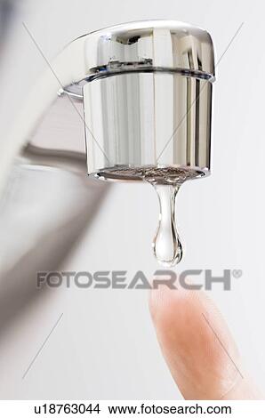 Picture - Water drips from kitchen tap.. Fotosearch