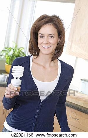Woman holding energy efficient compact flourescent bulb, Winnipeg, Canada View Large Photo Image Stock Photograph - Woman holding energy efficient compact flourescent bulb, Winnipeg, Canada. Fotosearch