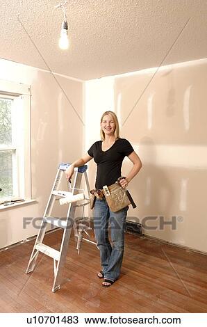 Woman holding paint roller, for home renovations View Large Photo Image Stock Image - Woman holding paint roller, for home renovations. Fotosearch