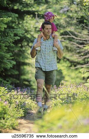Stock Photography - Dad carries daughter on shoulders, Whistler forest trail, Whistler, BC. Fotosearch