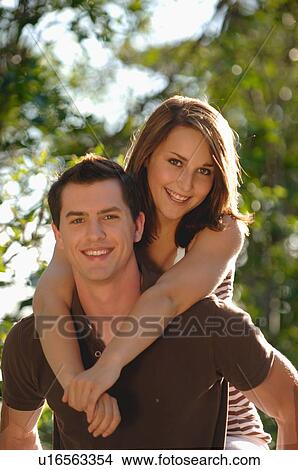 Teenage boy piggy backing teenage girl, Regina, Saskatchewan View Large Photo Image Picture - Teenage boy piggy backing teenage girl, Regina, Saskatchewan. Fotosearch