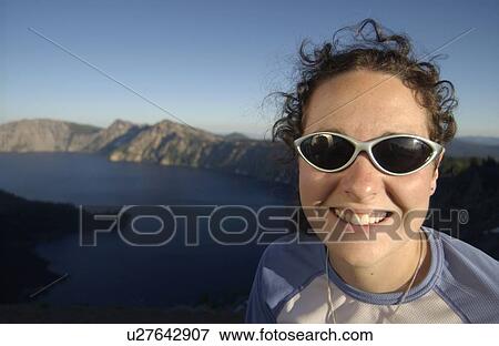 Woman (20-25) with sunglasses in front of lake and mountains, Crater Lake National Park, Oregon View Large Photo Image Stock Photo - Woman (20-25) with sunglasses in front of lake and mountains, Crater Lake National Park, Oregon. Fotosearch
