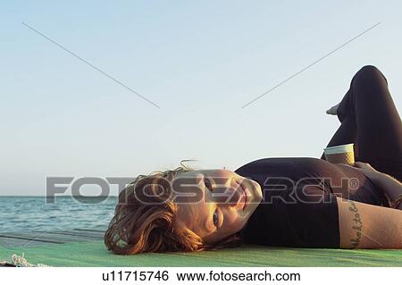 Woman lying on dock by lake, Clear Lake, Riding Mountain National Park, Manitoba, Canada View Large Photo Image Stock Photograph - Woman lying on dock by lake, Clear Lake, Riding Mountain National Park, Manitoba, Canada. Fotosearch