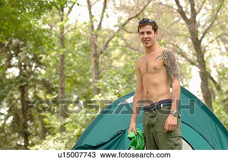 Stock Image - Young man w/tattoo in front of tent, Regina, Saskatchewan. Fotosearch