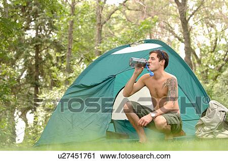 Stock Image - Young man w/tattoo in front of tent, Regina, Saskatchewan. Fotosearch