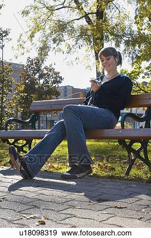 Young woman listening to Ipod outdoors, Brantford, Ontario View Large Photo Image Stock Photo - Young woman listening to Ipod outdoors, Brantford, Ontario. Fotosearch