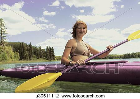 Stock Image - Young woman paddling kayak, Lake Katherine, Riding Mountain National Park, Manitoba, Canada. Fotosearch
