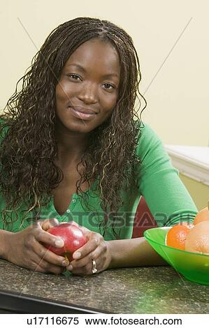 Stock Photography - African American woman in kitchen. Fotosearch