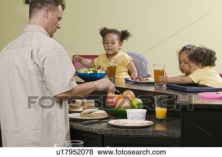 Caucasian dad preparing a meal for his Mulatto children, boy 1. 5 years, girl 3 and 6 years. View Large Photo Image Stock Photo - Caucasian dad preparing a meal for his Mulatto children, boy 1. 5 years, girl 3 and 6 years.. Fotosearch