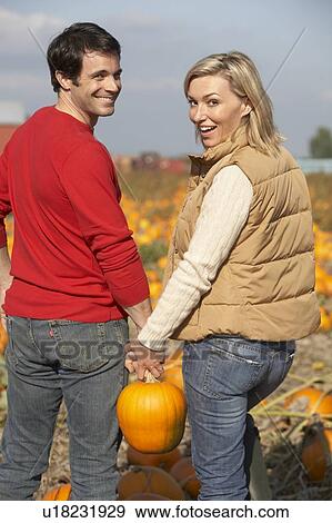 Stock Photo - Couple in organic pumpkin patch, Ladner, British Columbia, Canada. Fotosearch