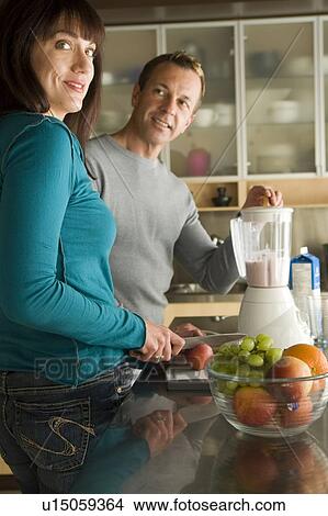 Couple making fruit smoothies with organic fruit, Winnipeg, Canada. View Large Photo Image Picture - Couple making fruit smoothies with organic fruit, Winnipeg, Canada. . Fotosearch
