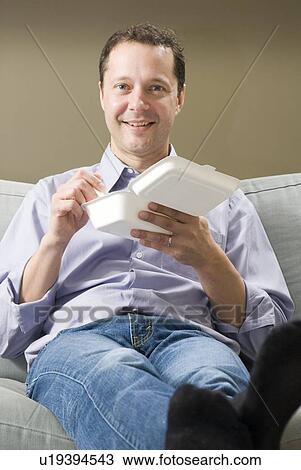 Stock Image - Man eating take-out food from corn-based compostable take-out containers, Winnipeg, Canada. Fotosearch