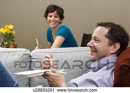 Stock Image - Man eating take-out food from corn-based compostable take-out containers, Winnipeg, Canada. Fotosearch