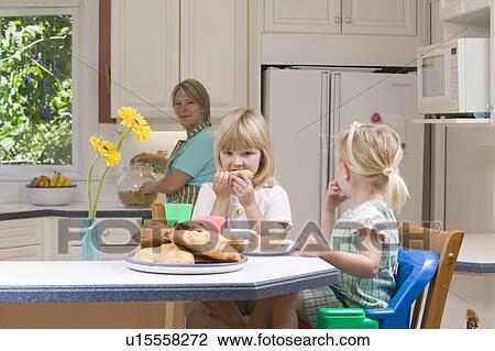 Stock Image - Mom and 3 and 5 year old daughters having breakfast, B. C.. Fotosearch