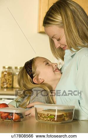 Stock Photograph - Mother and daughter preparing a healthy pack lunch. Fotosearch