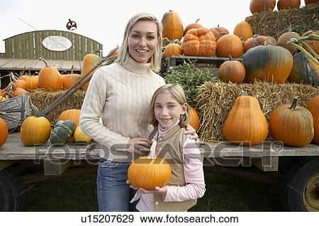 Mother with daughter holding organic pumpkin, Ladner, British Columbia, Canada View Large Photo Image Stock Photo - Mother with daughter holding organic pumpkin, Ladner, British Columbia, Canada. Fotosearch