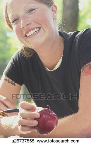 Smiling Woman holding apple, Wasagaming, Riding Mountain National Park, Manitoba, Canada View Large Photo Image Stock Photography - Smiling Woman holding apple, Wasagaming, Riding Mountain National Park, Manitoba, Canada. Fotosearch