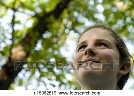 Stock Photo - Twelve year old girl under crab apple tree, Winnipeg, Canada. Fotosearch