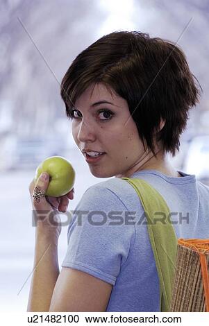 Stock Image - Young woman carrying bamboo mat and cloth shopping bag made with hemp fibres, Canada, Manitoba, Brandon. Fotosearch