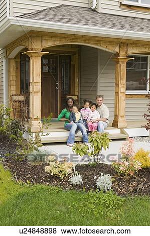 Stock Photo - AA mom, Caucasian dad, Mulatto Children, Boy 1. 5 years, girl 3 years, girl 6 years on the porch of their home. Abbotsford. BC. Fotosearch
