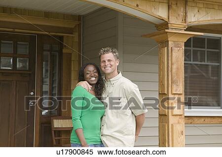 Stock Photography - African American woman and Caucasian man on the porch of theri house. Abbotsford, BC.. Fotosearch