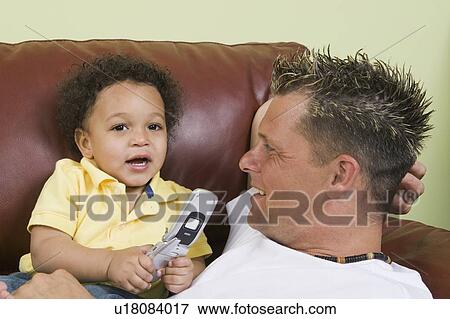 Stock Photo - Caucasian father and Mulatto boy (1. 5 years) and cellphone. Abbotsford, BC. Fotosearch