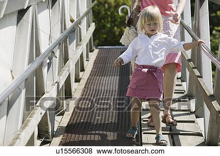 Stock Photo - Caucasian Mom and 4 year old Daughter, walking down a ramp to a boat dock, Granville Island. Fotosearch