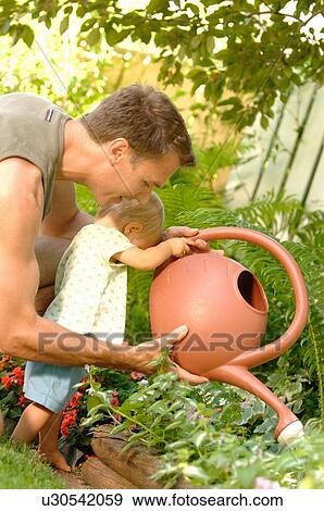 Dad & baby playing with watering can, Regina, Saskatchewan View Large Photo Image Stock Photo - Dad & baby playing with watering can, Regina, Saskatchewan. Fotosearch