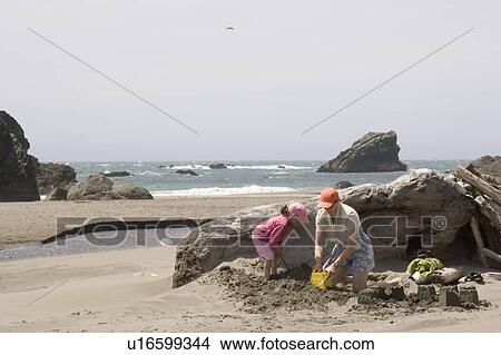 Picture - Mother and daughter play in sand on beach, Harris Beach State Park, Oregon, USA. Fotosearch