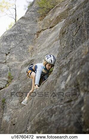 Stock Image - Young girl (age 7) climbing on granite cliff at Stone Hills near Rexford, Montana, USA. Fotosearch