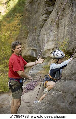 Young girl (age 7) preparing to climb while father belays at Stone Hills near Rexford, Montana, USA View Large Photo Image Stock Image - Young girl (age 7) preparing to climb while father belays at Stone Hills near Rexford, Montana, USA. Fotosearch
