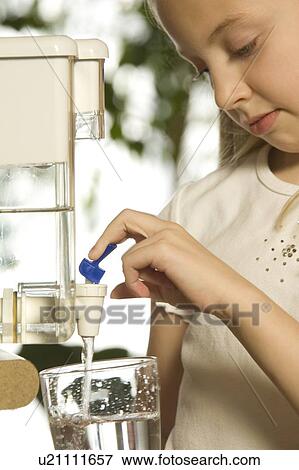 Young girl pouring filtered water View Large Photo Image Stock Photo - Young girl pouring filtered water. Fotosearch