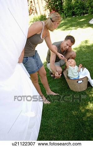 Young man and woman playing peekaboo w/child/clothesline, Regina, Saskatchewan View Large Photo Image Stock Photo - Young man and woman playing peekaboo w/child/clothesline, Regina, Saskatchewan. Fotosearch
