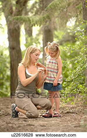 Stock Photo - Young woman and child in woods looking at scenery, Regina, Saskatchewan. Fotosearch