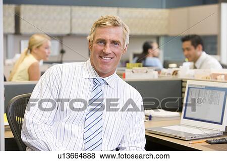 Businessman in cubicle smiling View Large Photo Image Stock Photo - Businessman in cubicle smiling. Fotosearch