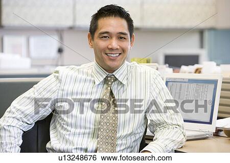 Businessman in cubicle smiling View Large Photo Image Stock Photograph - Businessman in cubicle smiling. Fotosearch