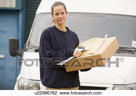 Deliveryperson standing with van with clipboard and box View Large Photo Image Stock Image - Deliveryperson standing with van with clipboard and box. Fotosearch