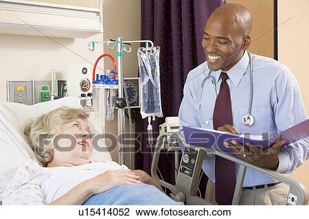 Stock Image - Doctor Making Notes About Patient. Fotosearch