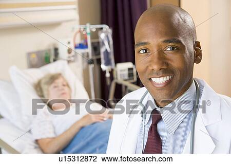 Stock Image - Doctor Smiling In Patients Room. Fotosearch