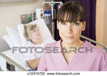 Stock Image - Nurse Standing In Patients Room. Fotosearch