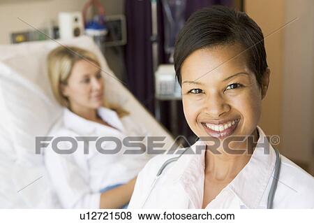 Stock Photo - Nurse Standing In Patients Room. Fotosearch