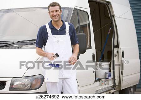 Stock Image - Painter standing with van smiling. Fotosearch