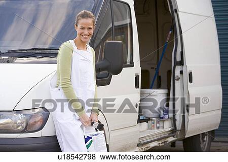 Stock Photo - Painter standing with van smiling. Fotosearch