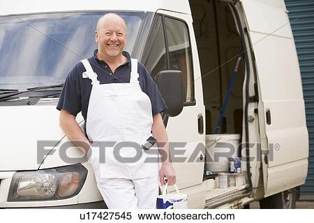 Stock Photography - Painter standing with van smiling. Fotosearch