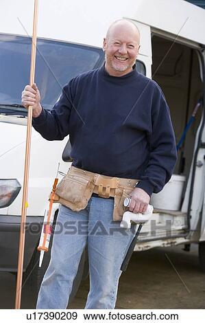 Plumber standing with van smiling View Large Photo Image Stock Photo - Plumber standing with van smiling. Fotosearch